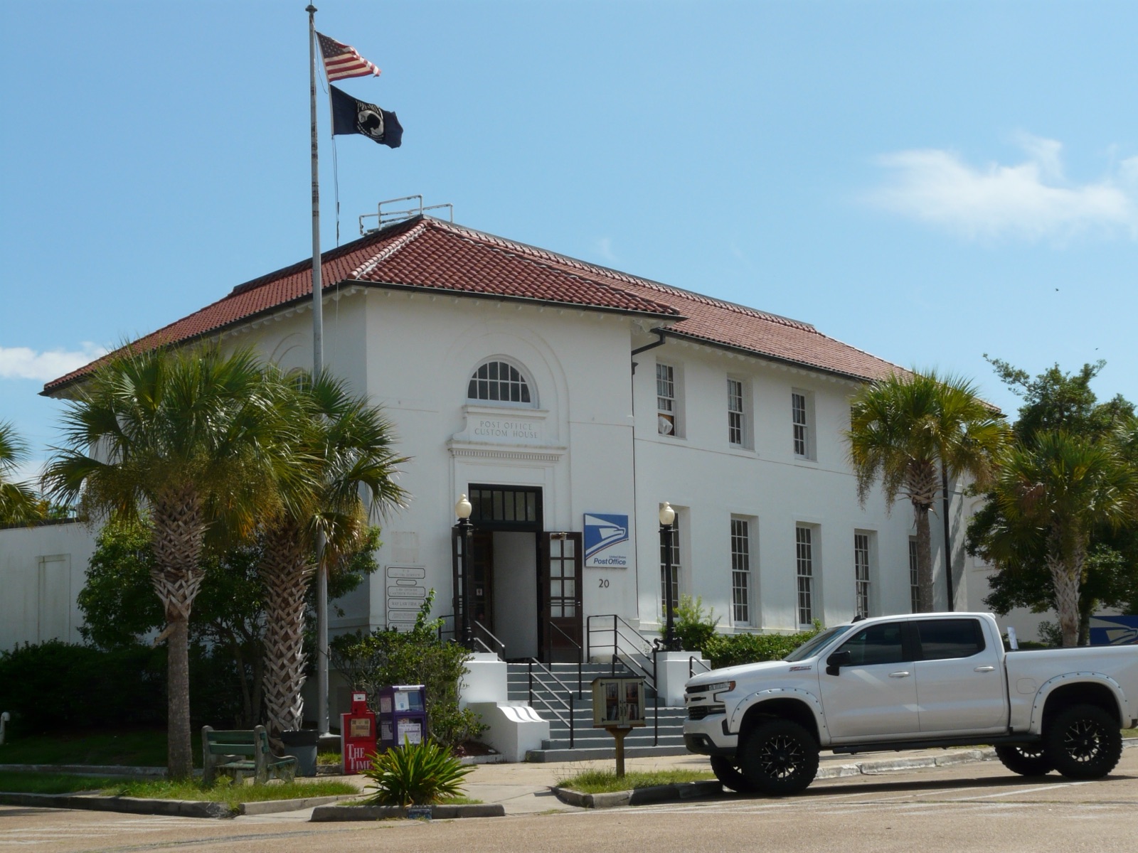 The historic white Post Office and Custom House, with its red-tile roof and palms, in downtown Apalachicola, Florida.