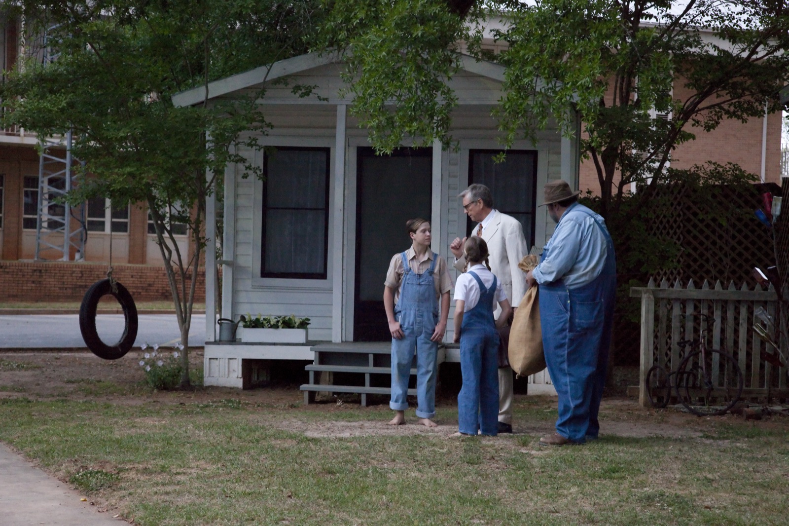 Actors in period costume performing a scene from To Kill a Mockingbird on an outdoor set in Monroeville, Alabama.