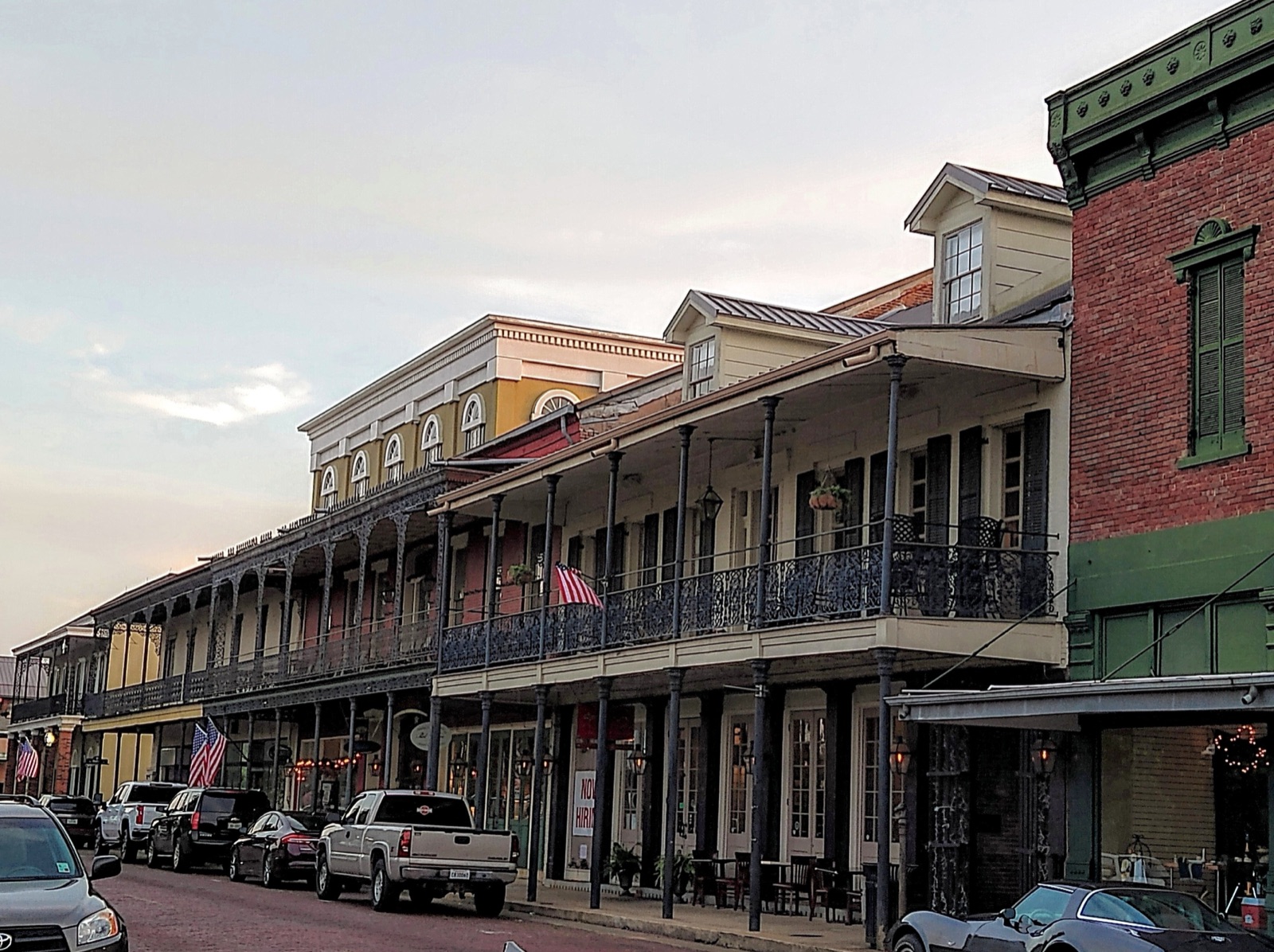 Historic brick-paved Front Street in downtown Natchitoches, Louisiana, with wrought-iron balconies along the Cane River.