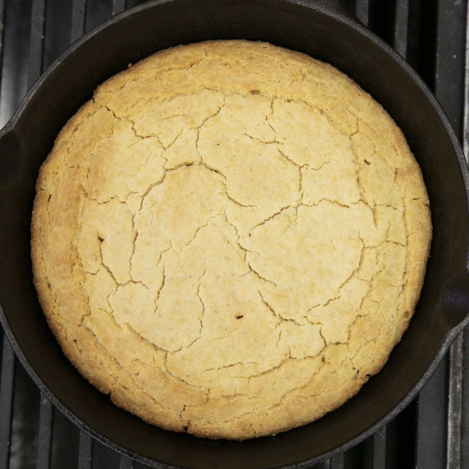 Golden Southern cornbread baked in a black cast-iron skillet.