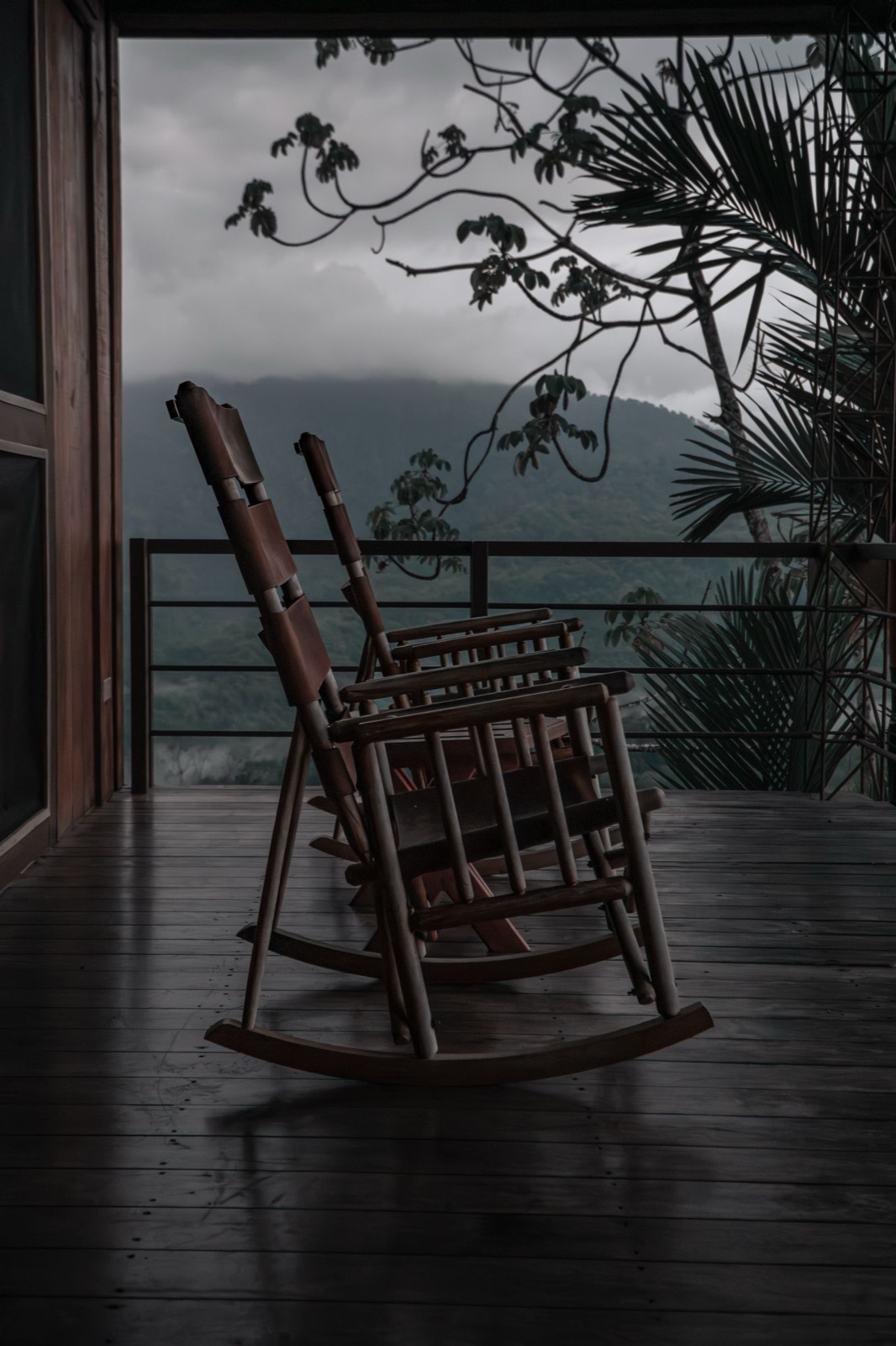 A lantern-lit Southern front porch on Halloween night, rocking chairs drawn close and faces turned toward a storyteller.