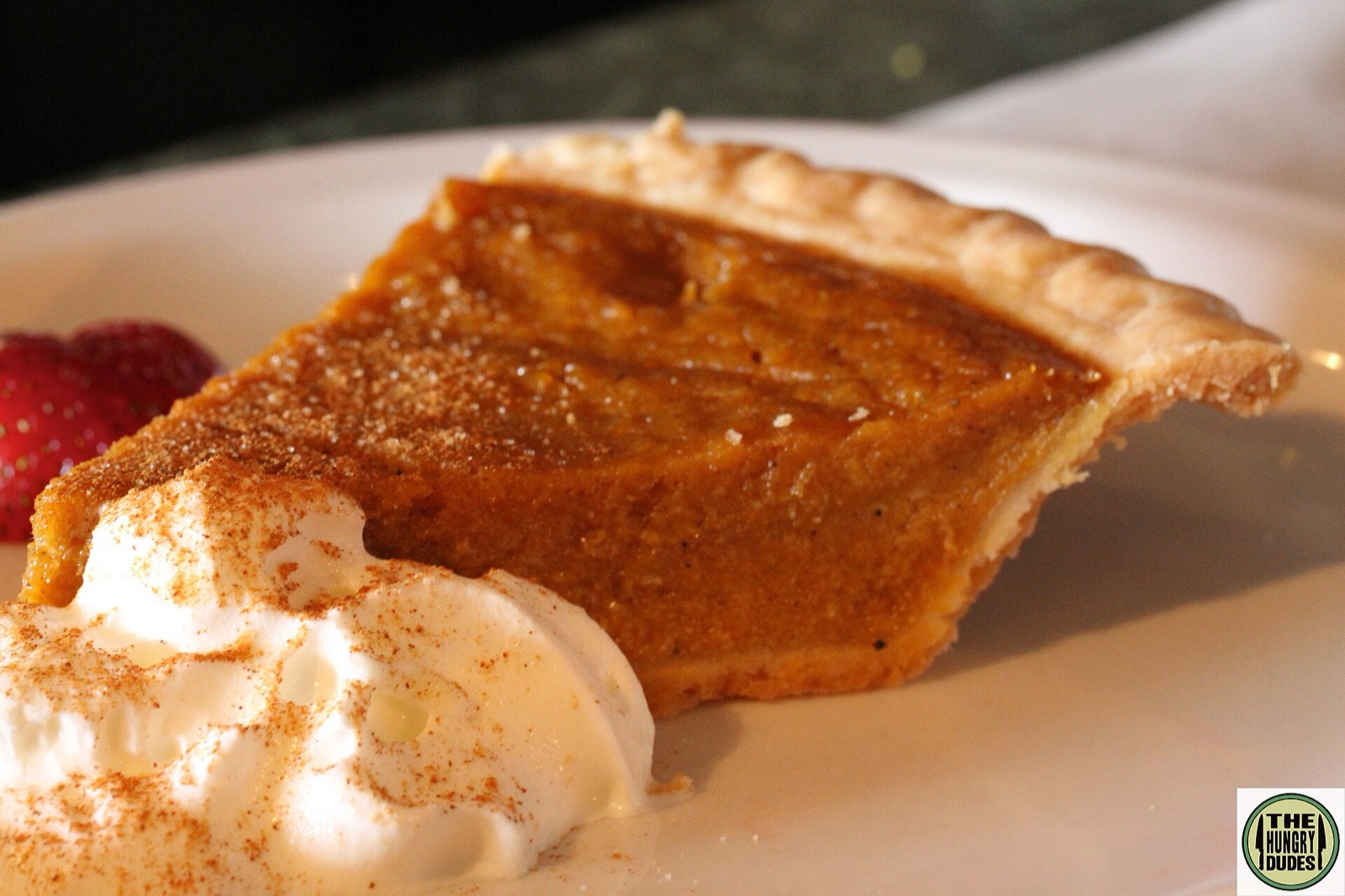 A deep-orange sweet potato pie in a golden crust, cooling on a windowsill in fall light.